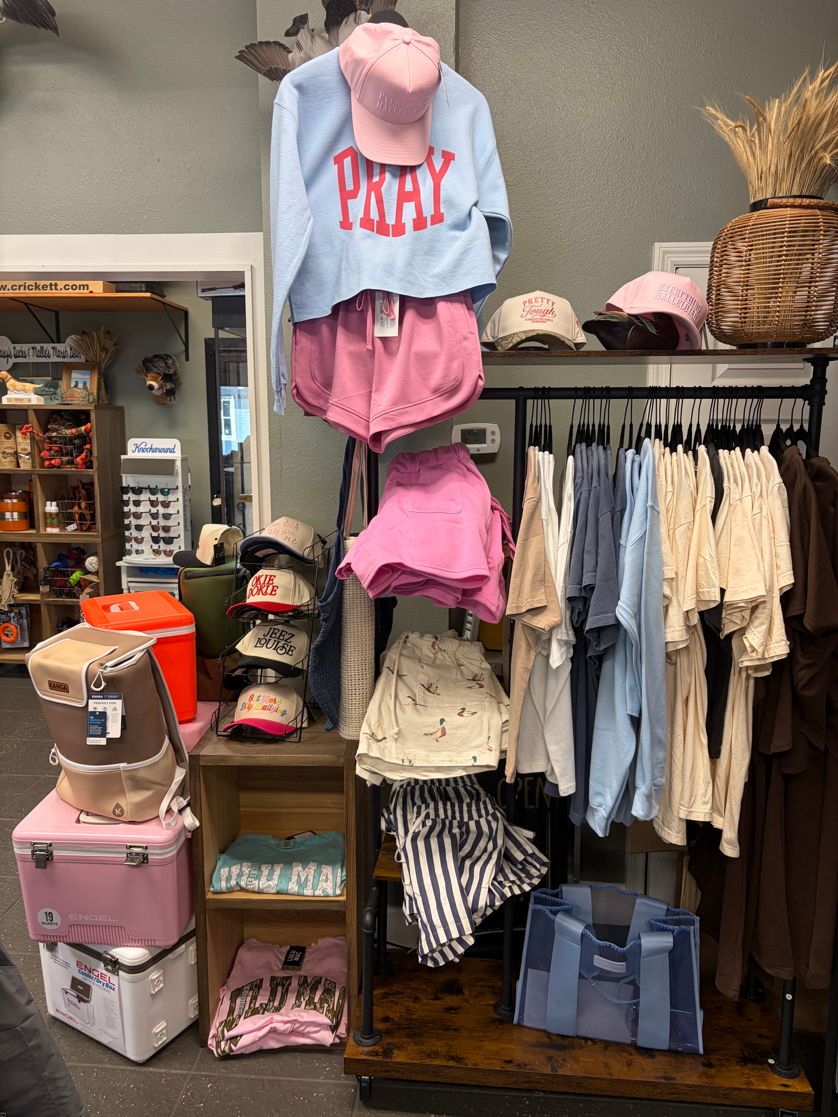 Women's apparel section with PRAY sweatshirts, hats and Engel coolers